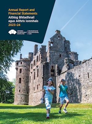 Front cover of HES Annual Report 2023-24. Two children running around the grounds of a castle wearing plastic helmets and holding plastic swords