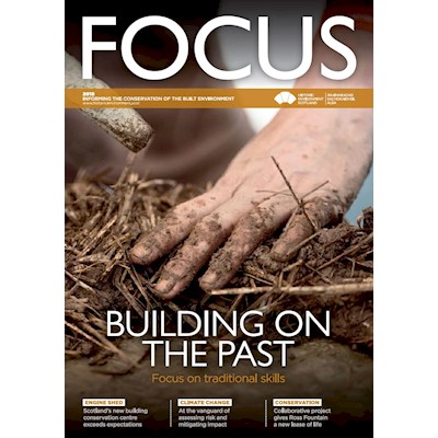 The cover of focus magazine 2018 with a photo of someone building using earth