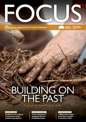 The cover of focus magazine 2018 with a photo of someone building using earth