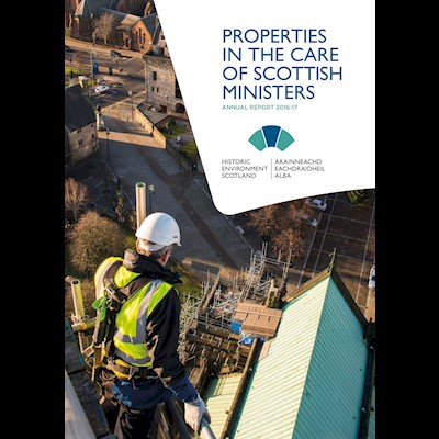 A photograph of a man in a high visibility jacket, looking over scaffolding to the roof of a building. The title is "Properties in the Care of Scottish Ministers: Annual Report 2016-17"