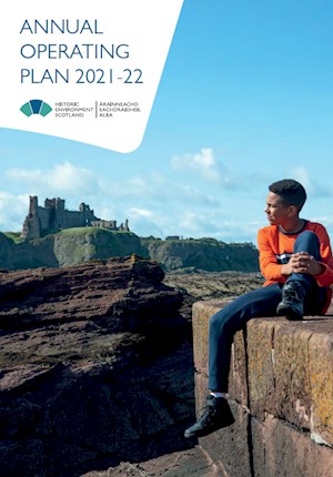 A child is sitting on rocks in front of Tantallon Castle in the East Lothian