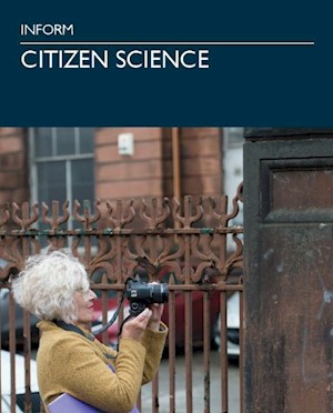 A person holding up a camera to ironwork railings attached to a historic sandstone building